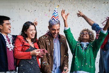 Happy multiracial people celebrating new year eve party throwing confetti - Focus on left girl face