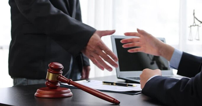 The Lawyer is currently handshake with the client about the success in resolving the case.