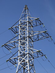Powerful electricity air power line mast tower top on blue sky background