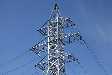 High voltage electric power line pylon top on blue sky background