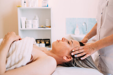 Obraz na płótnie Canvas Cosmetologist does facial massage for woman. Beauty skin care
