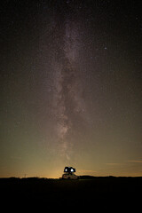 Naklejka na ściany i meble Long exposure view of the Milky Way on field with car rooftop tent