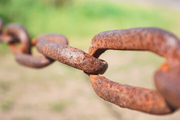 Old rusty chain on the field on the ground background