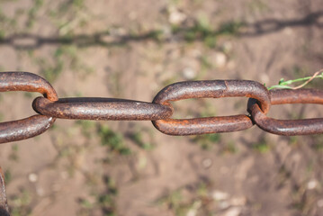 Old rusty chain on the field on the ground background