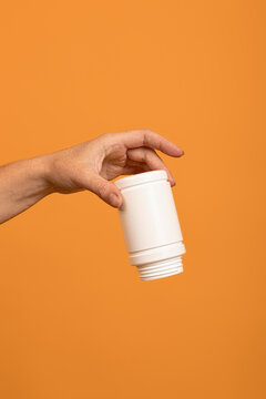 upside down empty white plastic sweetener bottle in hand. the concept of running out of dietary supplements