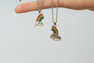 two pendants with silver clouds and halves of the rainbow with the inscription best friends on the...