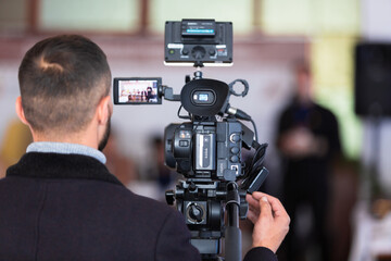 A man and a professional camera shoots a conference