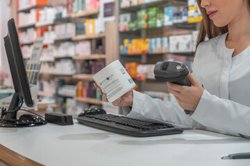 Mujer farmacéutica irreconocible, usando el lector de código de barras, para ver la información del producto.