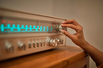 Anonymous woman adjusting knob on vintage receiver