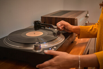 Crop person playing music on vintage record player