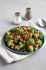 Homemade Broccoli Bacon Salad on a Plate on a gray background, side view.