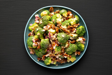 Homemade Broccoli Bacon Salad on a Plate on a black background, top view. Flat lay, overhead, from above.