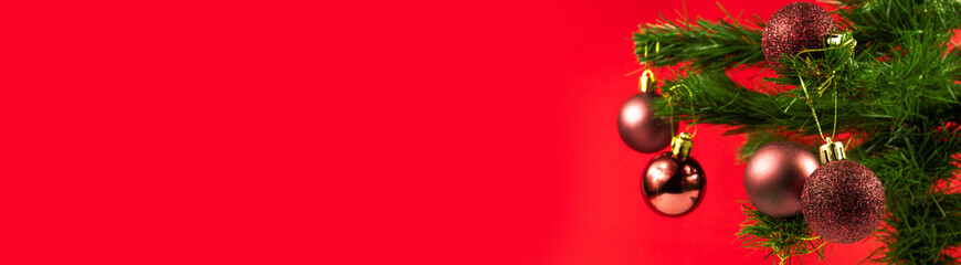 Christmas background. Christmas tree with shiny decorations on the red background. New year banner concept idea with copy space for text.