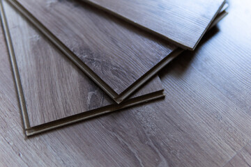 Installing laminated floor, detail on wooden tiles ready to be fit.