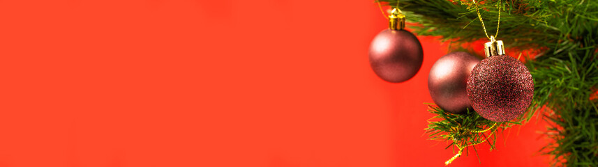 Christmas background. Christmas tree with shiny decorations on the red background. New year banner concept idea with copy space for text.