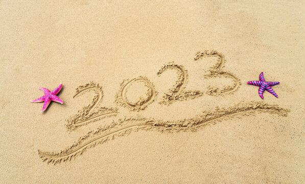 2023 handwritten with starfish in sand on a beautiful beach