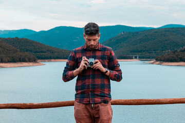 Half figure front view of a photographer taking pictures at Lago di Gusana near Gavoi at sunset in autumn with dramatic clouds