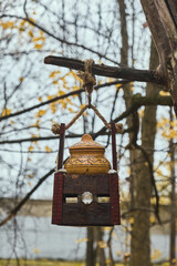 Wooden feeder for squirrels and birds on a tree in the autumn forest birdhouse