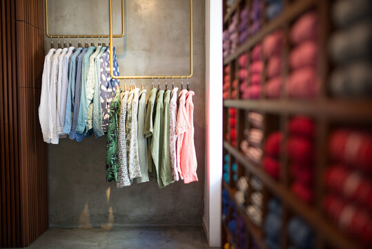 Image of dressing room with male clothes. Male shirts of different kinds and colors hanging on racks and laying on shelves. Man fashion, clothes and shopping concept