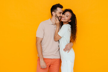 Multiracial happy couple hugging and making fun together