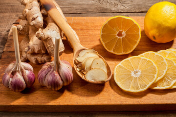 Cold remedy lemon and ginger with garlic on a wooden table. Prevention of human viral diseases.