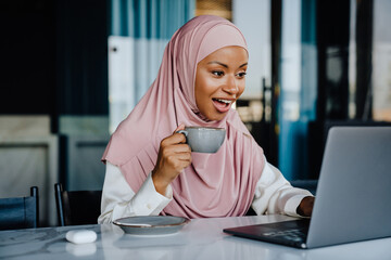 Muslim young businesswoman drinking coffee while working in office