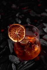 Cocktail with ice and dried orange slice.
