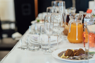 Luxurious restaurant. Luxurious interior, white tables, serving dishes and glasses for guests