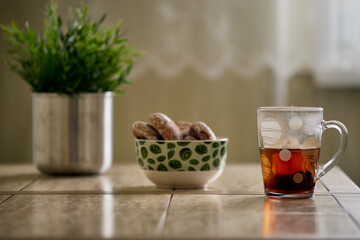 Close up picture of tea in transparent cup with biscuit cookies on a cotton napkin isolated on white background