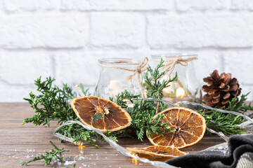 Background for christmas with burning candles and natural decoration on rustic wooden board. Background with pine branches and space for your text.