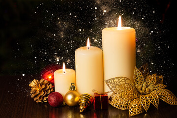 Christmas holiday card with  three burning candles and ornaments with bokeh light.