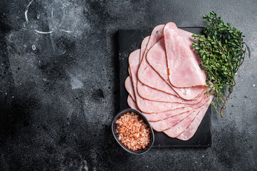 Squared slices of lean pork ham. Black background. Top view. Copy space