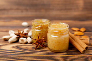 Honey in a glass jar. Nutty honey on a brown texture table. Remedy for colds and respiratory diseases. Organic product of a vegetarian diet. copy space.