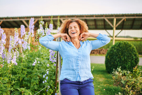 Outdoor Portrait Of Beautiful 50 Year Old Woman Enjoying Nice Day In Flower Park Or Garden, Happy And Healthy Lifestyle