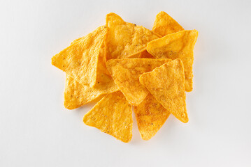Pile of nachos - crunchy Mexican triangular corn tortilla chips isolated on white background top view