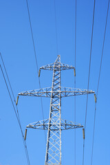 A high-voltage pylon against the blue sky on a sunny clear day. Equipment for transmitting electricity over long distances
