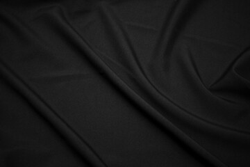 Texture of dark black fabric closeup. Low key photo. Plexus threads. Clothing industry. Abstract background. Black textile waves. Black cloth background