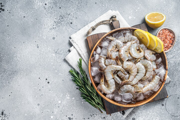 Uncooked Raw peeled tiger white shrimp prawn. Gray background. Top view. Copy space