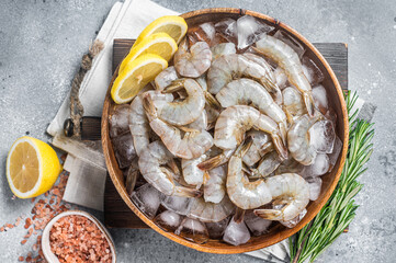 Uncooked Raw peeled tiger white shrimp prawn. Gray background. Top view - obrazy, fototapety, plakaty