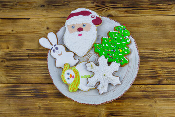 Christmas gingerbread cookies in a plate on a wooden table. Top view