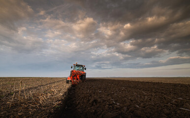 Tractor on the field during sunset.