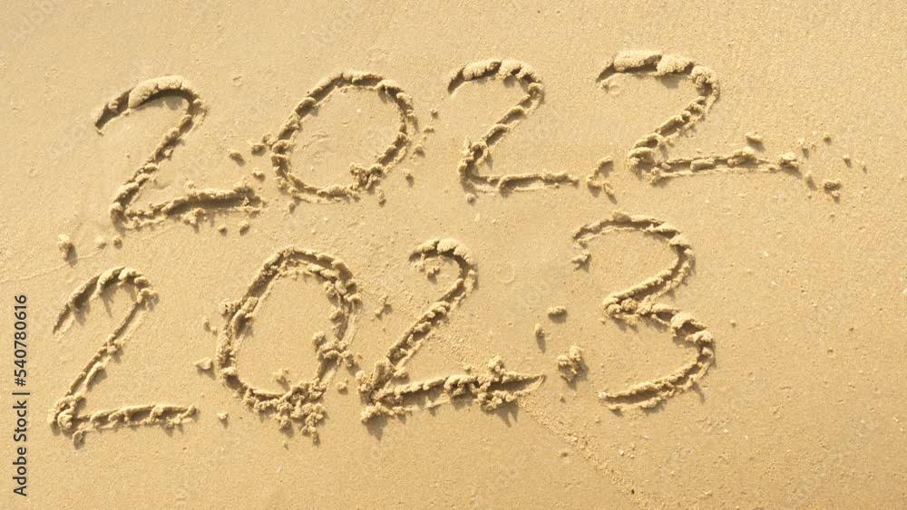 Wall mural message year 2022 replaced by 2023 written on beach sand background. goodbye 2022 hello to 2023 lapp