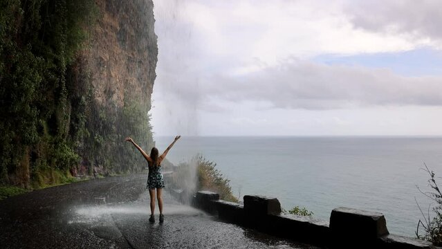 Cascata dos Anjos - woman standing under Angels waterfall in Madeira
