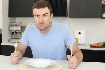 Impatient looking man waiting for dinner to be served 
