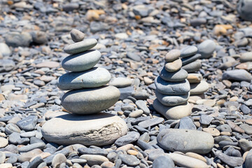 Fototapeta na wymiar Pebbles on the seashore are stacked in a pyramid. Rest and relaxation, a sense of balance.