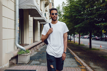 Stylish african american man in white blank t-shirt and sunglasses. Mock-up.
