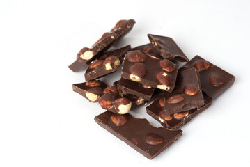 pieces of chocolate with nuts close-up isolated on white background. place for text