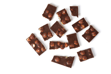 Small pieces of chocolate with nuts on a white background. top view