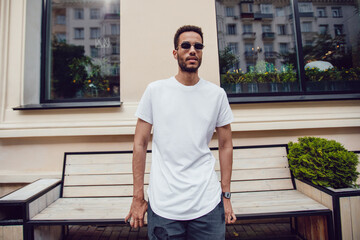 Fototapeta premium Stylish african american man in white blank t-shirt and sunglasses. Mock-up.