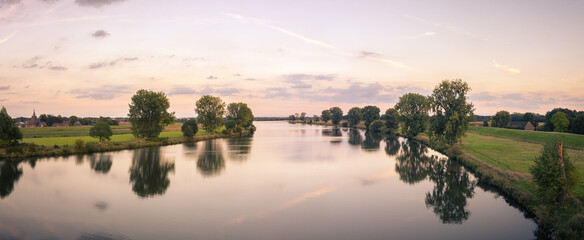 Panorama of the river Maas (Meuse) between Gelderland and North Brabant on summer evening, taken from the bridge between Ravenstein and Niftrik